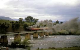 Steam train with passenger carriages crossing Derwent River