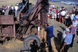 Man bagging grain at demonstration of Aveling & Porter steam engine and harvest machine